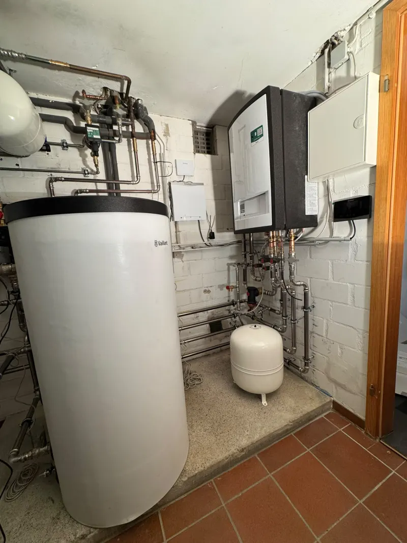 Technikraum mit Speicher, Wandgerät, Ausdehnungsgefäß und neu verlegten Rohrleitungen