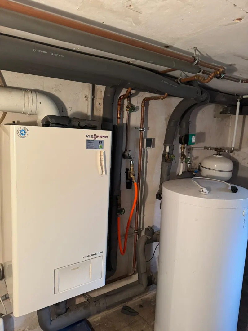 Gas-Brennwertgerät Viessmann Vitodens 300 an der Wand neben einem Speicher, mit gedämmten Leitungen und Ausdehnungsgefäß