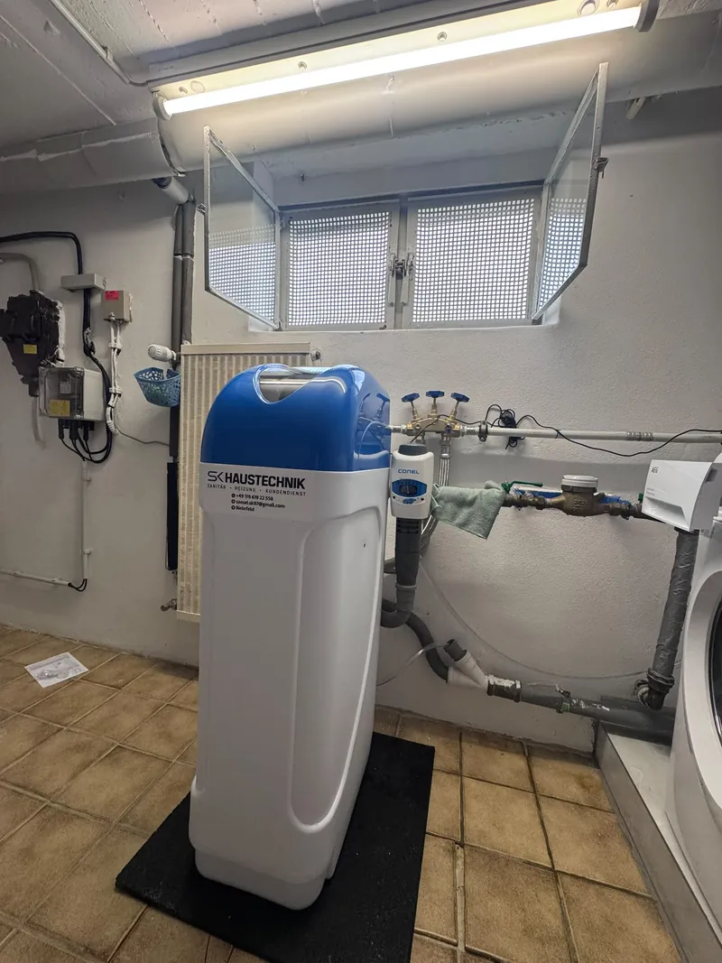 Installierte Wasserenthärtungsanlage in einem Kellerraum, angeschlossen an die Hauswasserleitung